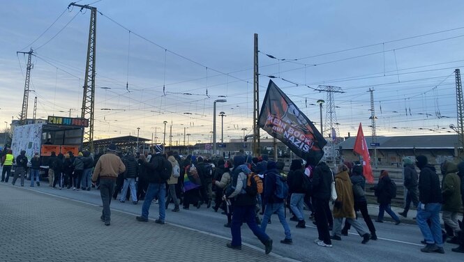 Viele Demonstrierende laufen vor dem Bahnhof entlang