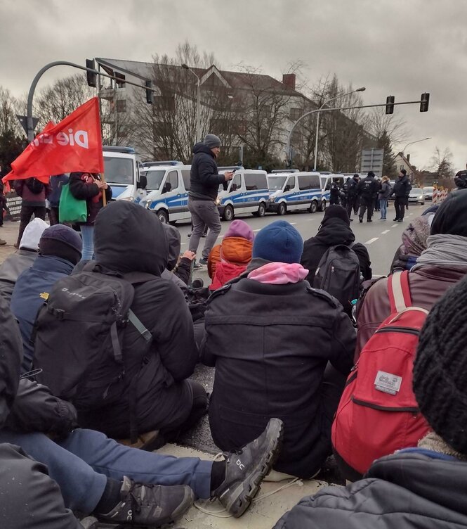 Sitzblockade und Flagge der Linken