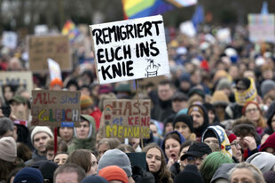 Demonstranten, mit Schild: Remigriert Euch ins Knie, bei einer Kundgebung vor dem Berliner Reichtstag