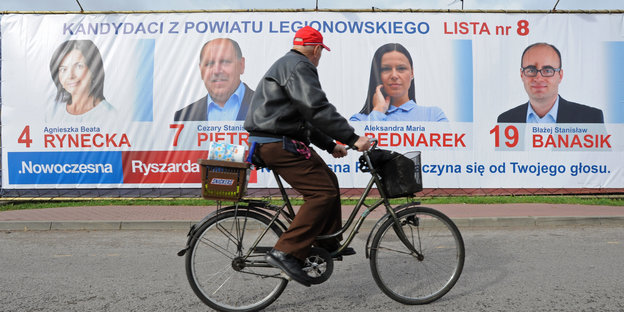Ein Radfahrer fährt in Jablonna, in der Nähe von Warschau, an Wahlplakaten vorbei.