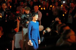 Sahra Wagenknecht in einem blauen Kleid in einem dunklen Saal