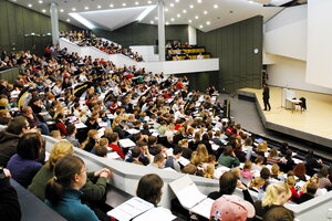 Studierende verfolgen eine Vorlesung in einem gut gefüllten Hörsaal der Kieler Christian-Albrechts-Universität.