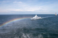 Ein Regenbogen vor Militärschiffen