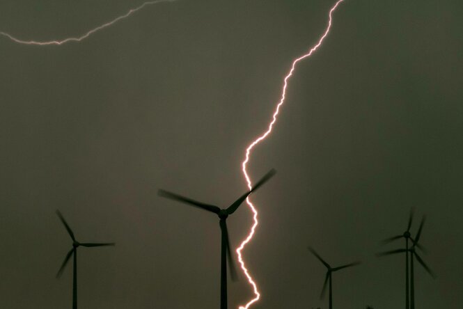 Blitze hinter Windrädern.