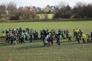 Anti-AfD-Protestierende am Wochenende in Riesa laufen über ein Feld