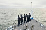 Soldaten schauen von einem Schiff aus auf Wasser