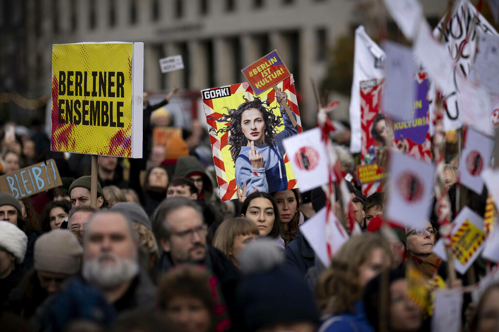 Eine Menschenmenge protestiert mit Plakaten verschiedener Berliner Theater