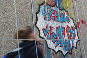 Ein Mädchen läuft an der Fichtenberg-Oberschule in Berlin-Steglitz an Graffiti mit dem Schrift 