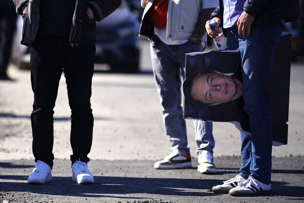 Drei Männerbeine mit Jeans und weißen Sneakern, einer trägt eine Tasche mit Musk Porträt