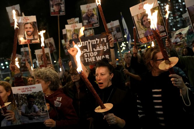 Feiernde Menschen mit Fackeln und Plakaten mit Fotos