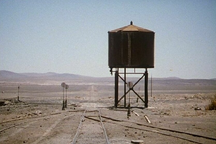 Ein Wasserturm steht in einer ausgetrockneten Landschaft.