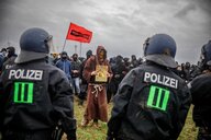 Eine als Mönch verkleidete Person bei Protesten.