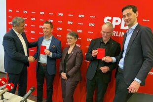 Die Berliner SPD überreicht zwei neuen Mitgliedern ihr Parteibuch. SPD-Fraktionschef Raed Saleh (l-r), Sebastian Schlüsselburg, die Co-Landesvorsitzende Nicola Böcker-Giannini, Oliver Nöll und Co-Landeschef Martin Hikel