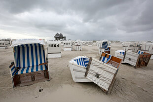 Strandkörbe am Strand von St. Peter-Ording. Einige sind vom Sturm umgeworfen worden