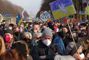 Demonstrantinnen und Demonstranten stehen zusammen gegen den Ukraine-Krieg