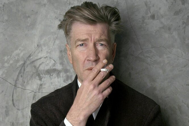 David Lynch hält eine Zigarette vor seinen Mund.