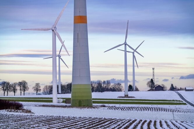 Viele Windkrafträder stehen in einer winterlichen Landschaft