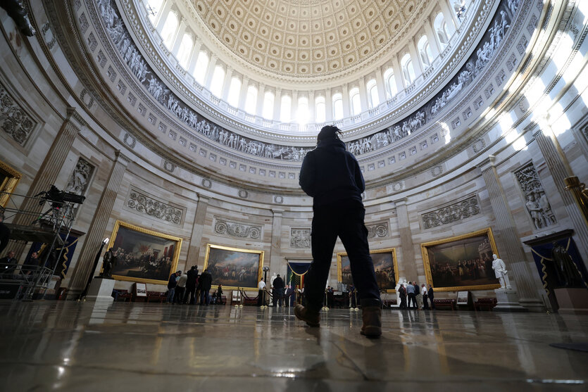 Rotunde im US.Kapitol. Vorne sieht man einen Mann von hinten, im Hintergrund bauen Leute etwas auf