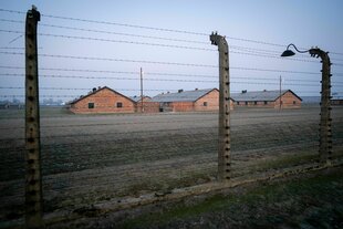 Stacheldrahtzäune und Baracken des früheren Vernichtungslagers Auschwitz-Birkenau sind am frühen Morgen zu sehen