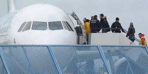 Flüchtlinge werden in ein Flugzeug gebracht