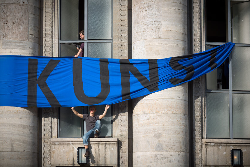 EIn Banner mit der Aufschrift "Kunst" hängt an der Volksbühne