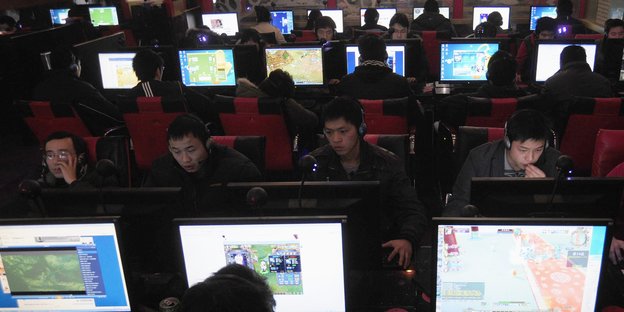 Mehrere junge Menschen sitzen in China in einem Interncafé
