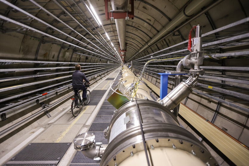 Eine Person fährt mit einem Fahrrad in einem Tunnel einer technischen Einrichtung.