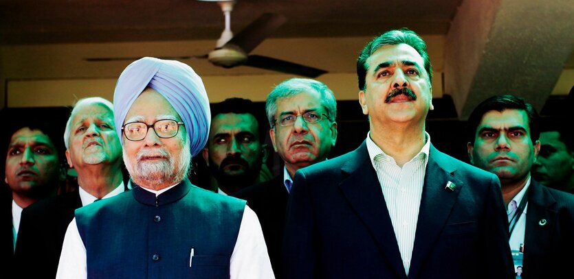 Der indische Premierminister Manmohan Singh steht neben seinem pakistanischen Kollegen Yusuz Raza Gilani, dahinter weitere Männer