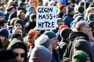 Menschen demonstrieren, in der Menschenmenge hält einer ein Schild mit den Worten 