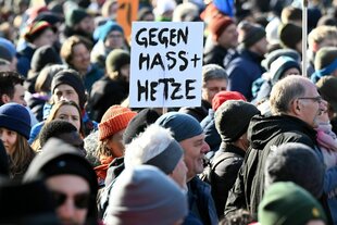 Menschen demonstrieren, in der Menschenmenge hält einer ein Schild mit den Worten "Gegen Hass Und Hetzte"