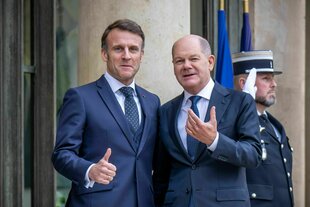 Emmanuel Macron und Olaf Scholz stehen dicht nebeneinander