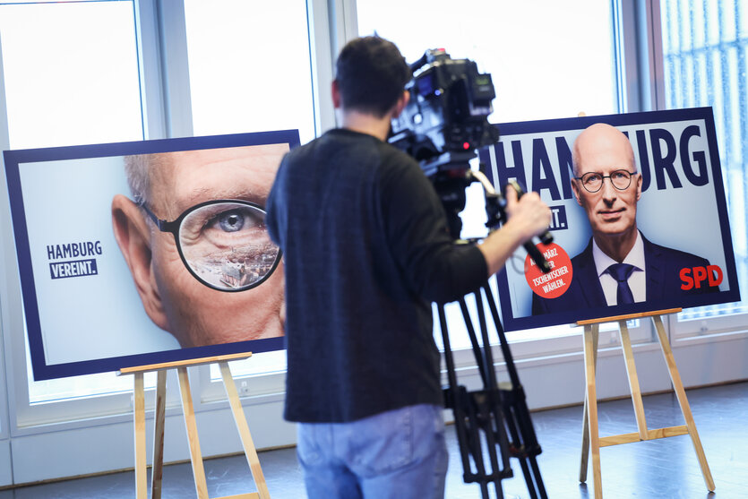 Ein Kameramann filmt zwei Wahlplakate mit dem Konterfei Peter Tschentschers auf Staffeleien