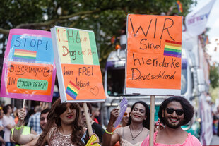 Queere Geflüchtete danken beim CSD mit Pappschildern Deutschland