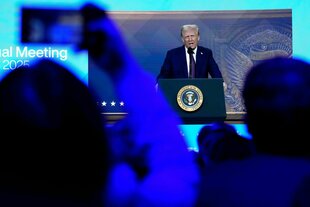 Donald Trump nimmt in Davos virtuell teil und ist sprechend auf einer großen Leinwand zu sehen