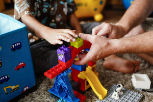 Ein Kind und ein Erwachsener spielen mit Spielzeug