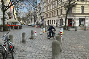 Poller und RadfahrerIn auf einer Straßenkreuzung