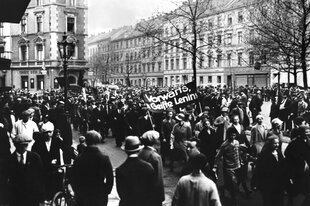 Große Demonstration auf der Straße, KPD-Mitglieder tragen ein Transparent mit der Botschaft: Vorwärts, im Geiste Lenins