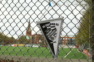 Ein Teutonia-Wimpel hängt am Zaun vorm Sportplatz