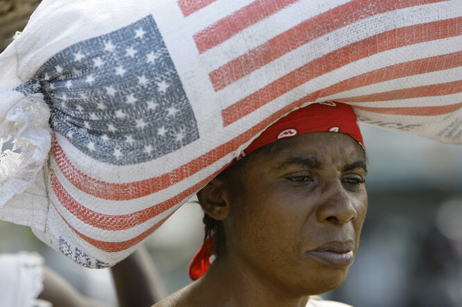 Eine Frau trägt einen Reissack bedruckt mit Amerikanischer Flagge