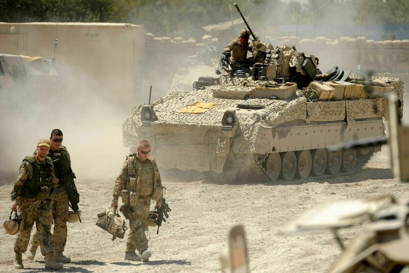 Bundeswehrsoldaten kommen nach einem Einsatz in das Polizeihauptquartier von Tscharah Darah (Afghanistan). Hinter ihnen rollt dabei ein Schützenpanzer vom Typ «Marder».