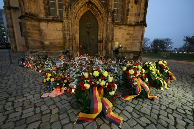 Kränze liegen vor einer Kirche.