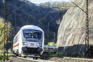 Ein Zug der Deutschen Bahn schlängelt sich die Felsen entlang