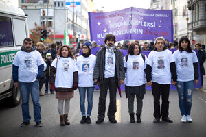 Angehörige von NSU Opferns stehen mit T-Shirts, auf denen die Fotos der getöteten Opfer des NSU abgebildet sind, in einer Reihe vor einem Demonstrationszug