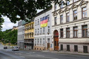 Ein Wohnhaus mit einer Deutschlandfahne.