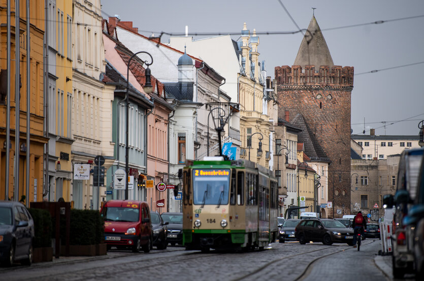 Eine Straßenbahn fährt an hostorischen Gebäuden in Brandenburg an der Havel vorbei