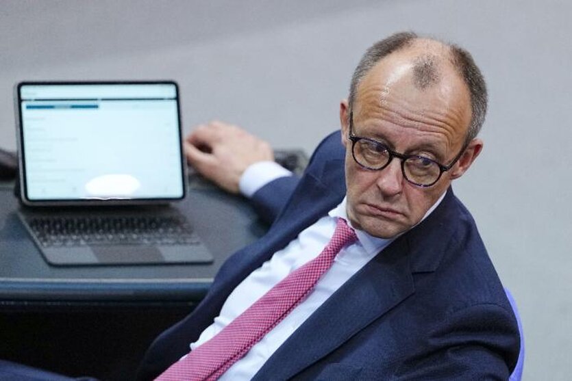 Friedrich Merz sitzt im Bundestag vor seinem Ipad