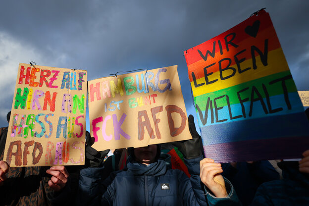 Teilnehmende einer Protestaktion unter dem Motto «Menschenkette gegen die AfD und ihre menschenfeindliche Politik» demonstrieren mit Schilder