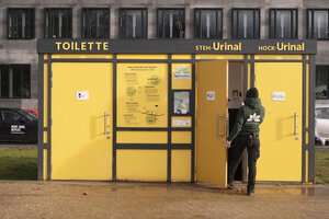 Eine Ökotoilette am Invalidenpark in Berlin-Mitte von außen. Eine Mitarbeiterin der Betreiberfirma geht gerade hinein für eine Inspektion