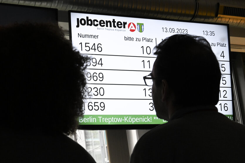 Personen im Wartebereich eines Jobcenters.