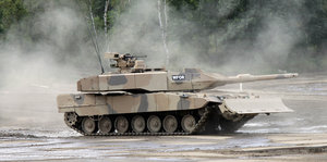 Ein Panzer fährt über einen Übungsplatz.